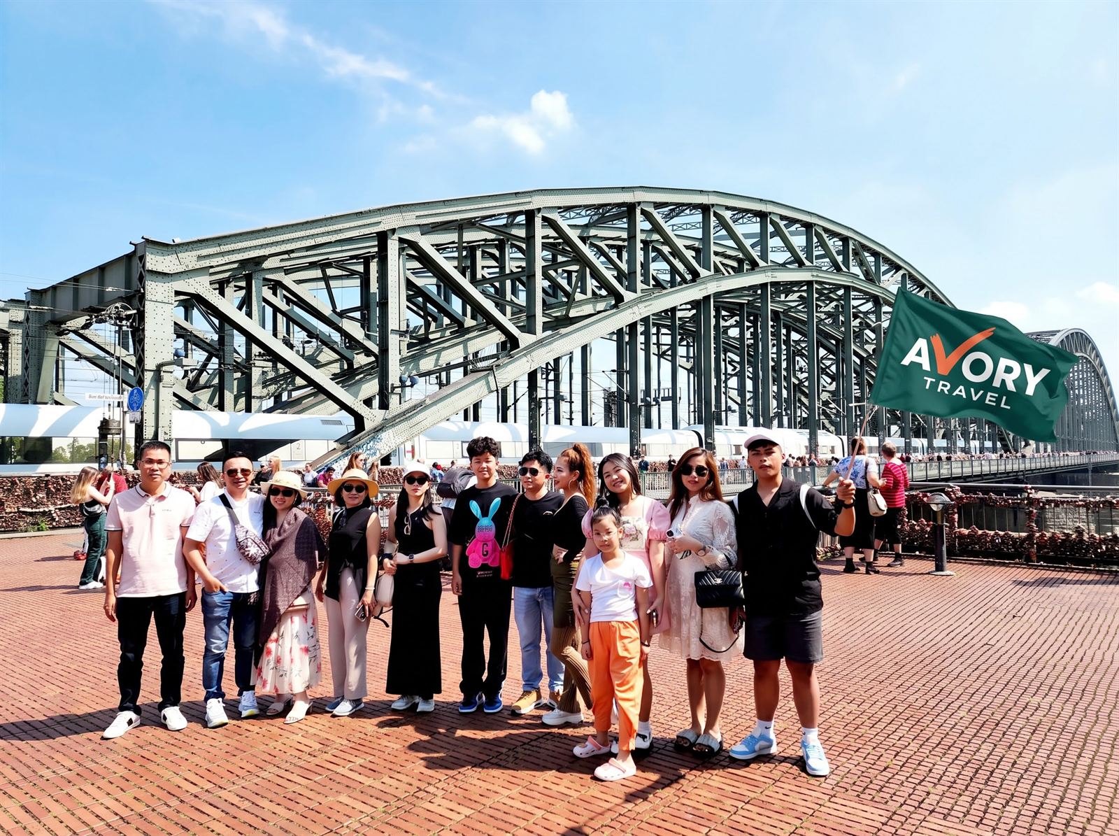 Đoàn khách AVORY bên cầu Hohenzollern, Köln (Đức), cầm cờ AVORY Travel